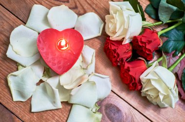 ahşap arka plan üzerinde kırmızı mum ile kırmızı gül demet