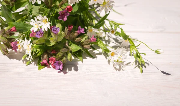 Em antecipação da festa da Trindade. Flores de campo fresco e fundo de madeira branca — Fotografia de Stock