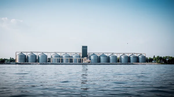 Grain elevator on the river bank. Storage of agricultural crops — Stock Photo, Image