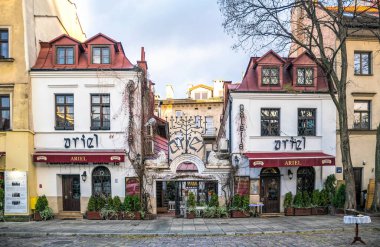 Krakow / Polonya - 30 Kasım 2019: Krakow, Polonya 'daki Kazimierz' in eski Yahudi mahallesinde kaldırımda bulunan kafe. Geleneksel Polonya ve Yahudi mutfağı. Tarihi cadde boyunca turist yürüyüşü