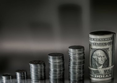 Gümüş bir arka planda çeşitli değerlerde para yığınları. Yatırımlar ve Tasarruf