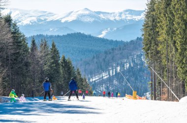 Palianytsa köyü, Ivanofrankivsk bölgesi, Ukrayna - 14 Ocak 2021: Kayakçılar ve snowboardcular Ukrayna 'nın Karpat dağlarındaki Bukovel kayak merkezinde dinleniyorlar. Aktif dinlenme ve tatiller