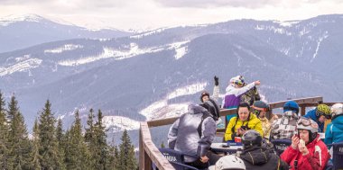 Palianytsa köyü, Ivanofrankivsk bölgesi, Ukrayna - 14 Ocak 2021: Kayakçılar ve snowboardcular Ukrayna 'nın Karpat dağlarındaki Bukovel kayak merkezinde dinleniyorlar. Aktif dinlenme ve tatiller