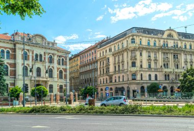 Budapeşte, Macaristan - 29 Ağustos 2019: Budapeşte, Macaristan 'daki eski evlerin cepheleri ve çevre yolu. Trafiğin en yoğun olduğu saatte Tuna Nehri boyunca bir şehir caddesi boyunca giden arabalar