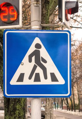 Yol kavşağında mavi yaya geçidi işareti
