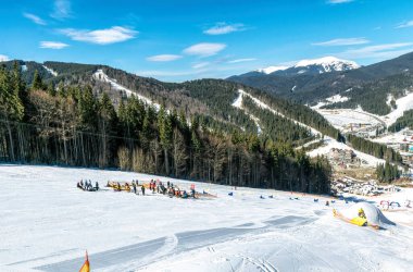 Palianytsa köyü, Ivanofrankivsk bölgesi, Ukrayna - 14 Ocak 2021: Kayakçılar ve snowboardcular Ukrayna 'nın Karpat dağlarındaki Bukovel kayak merkezinde dinleniyorlar. Aktif dinlenme ve tatiller