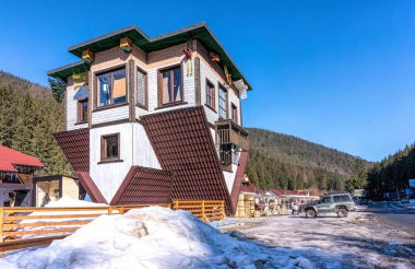 Polyanytsia köyü, Ivano-Frankivsk bölgesi, Ukrayna - Fabruary 28, 2021: Bukovel kayak merkezindeki Polyanytsya köyündeki komik Aşağı Ev ve kırsal fuarın ünlü binası