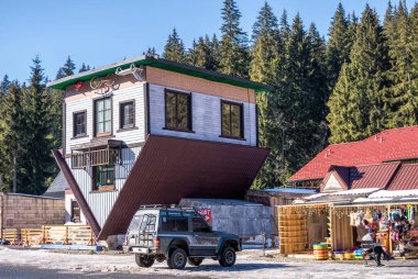 Polyanytsia köyü, Ivano-Frankivsk bölgesi, Ukrayna - Fabruary 28, 2021: Bukovel kayak merkezindeki Polyanytsya köyündeki komik Aşağı Ev ve kırsal fuarın ünlü binası