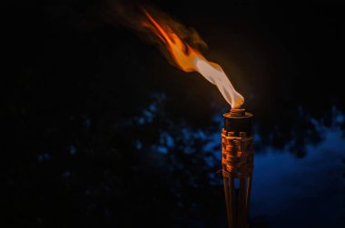 Karanlık gece ve yanan bir meşalenin ışığı