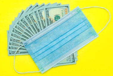 Tıbbi maske ve Amerikan dolarları.