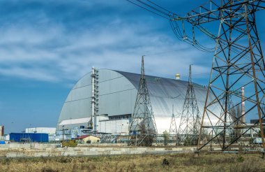 Pripyat şehri, Kiev bölgesi, Ukrayna - 13 Nisan 2019: Çernobil nükleer santralinin acil durum dördüncü güç ünitesinde metal hangar barınağı ve Çernobil felaketinin kurbanları için bir anıt