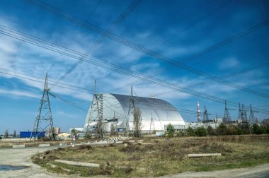 Pripyat şehri, Kiev bölgesi, Ukrayna - 13 Nisan 2019: Çernobil nükleer santralinin acil durum dördüncü güç ünitesinde metal hangar barınağı ve Çernobil felaketinin kurbanları için bir anıt