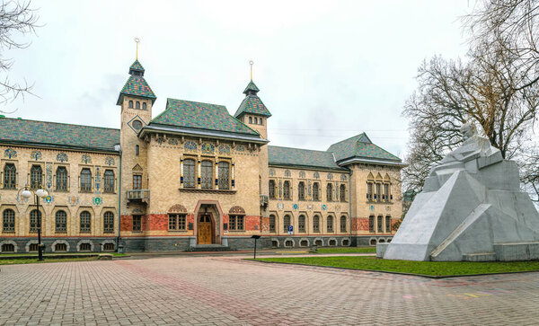 Полтава, Украина - 14 апреля 2021 года: Фасад здания Краеведческого музея и памятник поэту Тарасу Шевченко в городе Полтава, Украина. Популярная историческая туристическая достопримечательность