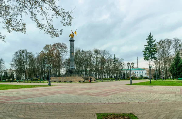 ウクライナのポルタヴァ 2021年4月14日 ウクライナの国旗と都市公園の緑の花壇 ウクライナのポルタヴァにあるコープニー公園の記念柱 人気の歴史的観光名所 — ストック写真