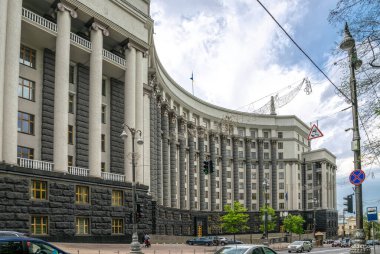 Kyiv, Ukrayna - 14 Mayıs 2021: Başkent Kiev 'deki Ukrayna Hükümeti Bakanlar Kurulu binasının görkemli cephesi. Uzun, sütunlu, at nalı şeklinde bir ofis binası ve trafik.