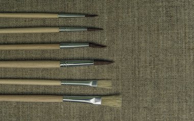 Bir tuvalin arka planına çizim yapmak için fırçalar