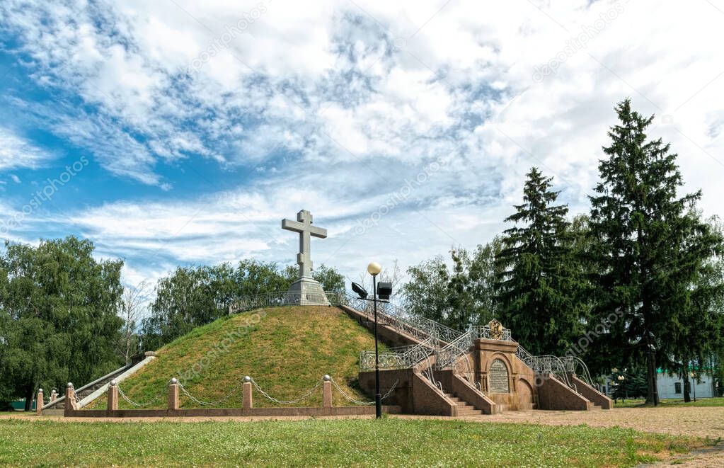Poltava, Ukraine - May 24 2021: Stone cross and bronze coat of arms of the Russian Tsar Peter the Great on mass grave of Russian soldiers, who died during the Battle of Poltava with the Swedes in 1709