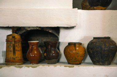 Kil sürahiler ve çömlekler. Fırının rafında geleneksel kırsal sofra takımı var.