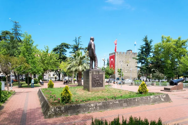Trabzon, Türkiye - 14 Haziran 2021: Türkiye 'nin Trabzon kentindeki tarihi Atapark' ta Atatürk 'ün bronz heykeli, Mustafa Kemal. Antik bir Bizans kalesinin heybetli taş duvarları dalgalanan Türk bayrakları ve yeşil bir tropikal şehir parkı