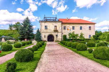 Zolochiv, Lviv bölgesi, Ukrayna - 04 Eylül 2021: Ukrayna 'nın Zolochiv kentinde bir ortaçağ kalesi ve yeşil çiçek açan bir bahçe inşa edildi. Yenilenmiş antik bina, 