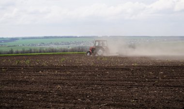 Ukrayna, sürülmüş bir alan ve bir traktör toz