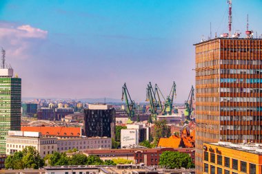 Gdansk, Poland - June 02, 2024: Sunny morning colourful urban skyline in Gdansk. Modern office buildings and cranes in the historic shipyard