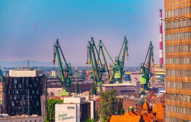 Gdansk, Poland - June 02, 2024: Sunny morning colourful urban skyline in Gdansk. Modern office buildings and cranes in the historic shipyard