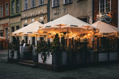 Gdansk, Polonya - 14 Aralık 2025: Parlak akşam Noel süslü kaldırım kafesi ve Gdansk 'ta soğuk kış şehir havası