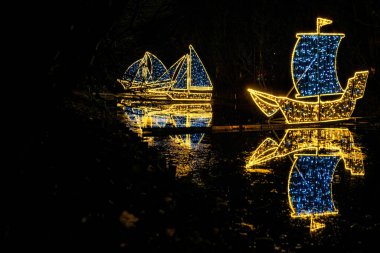 Gdansk caddesindeki güzel Noel ışıkları süslemeleri. Gece Oliwa parkında parlak ışıklar