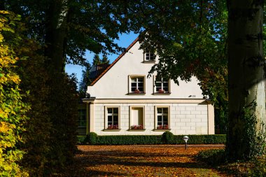 Gdansk, Polonya - 19 Ekim 2025: Renkli sonbahar bahçeleri arasında varlıklı güzel bir banliyö evi. Avrupa mimarisi ve şehir hayatı