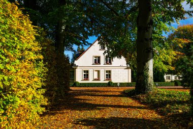 Gdansk, Polonya - 19 Ekim 2025: Renkli sonbahar bahçeleri arasında varlıklı güzel bir banliyö evi. Avrupa mimarisi ve şehir hayatı