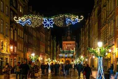 Gdansk, Polonya - 25 Aralık 2025: Gdansk 'taki Eski Şehir' deki güzel renkli antik evler ve tarihi binalar. Noel süslenmiş sokakta yürüyen turistler