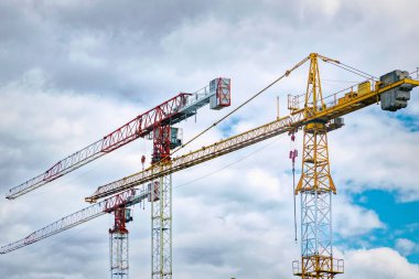 Mavi gökyüzü arka planında demir inşaat vinçleri