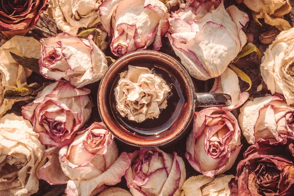 Xícara de café e uma delicada rosa seca — Fotografia de Stock