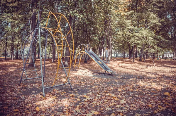 Opuszczony plac zabaw w jesieni Park — Zdjęcie stockowe