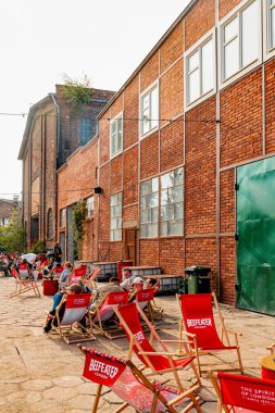 Gdansk, Polonya - 10 Mayıs 2025: Gdansk 'taki tarihi tersanenin ünlü turizm ve eğlence alanı. Yıkılan endüstri binaları, vinçler ve gıda alanlarından yiyecek alan insanlar.