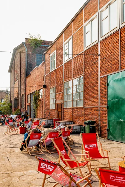 Gdansk, Polonya - 10 Mayıs 2025: Gdansk 'taki tarihi tersanenin ünlü turizm ve eğlence alanı. Yıkılan endüstri binaları, vinçler ve gıda alanlarından yiyecek alan insanlar.