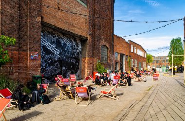 Gdansk, Polonya - 10 Mayıs 2025: Gdansk 'taki tarihi tersanenin ünlü turizm ve eğlence alanı. Yıkılan endüstri binaları, vinçler ve gıda alanlarından yiyecek alan insanlar.