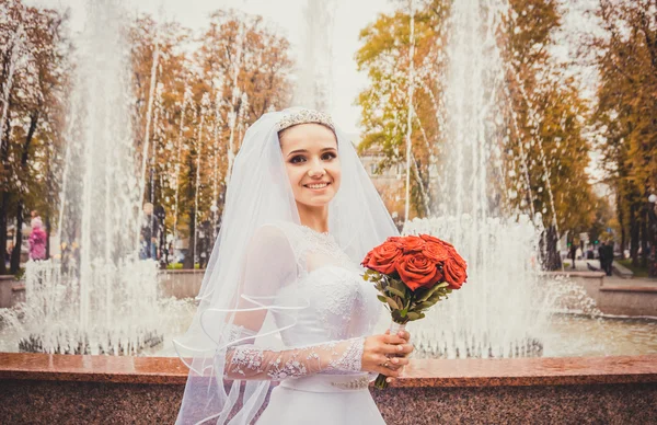 Прекрасная нежная невеста на фоне праздничного фонтана — стоковое фото
