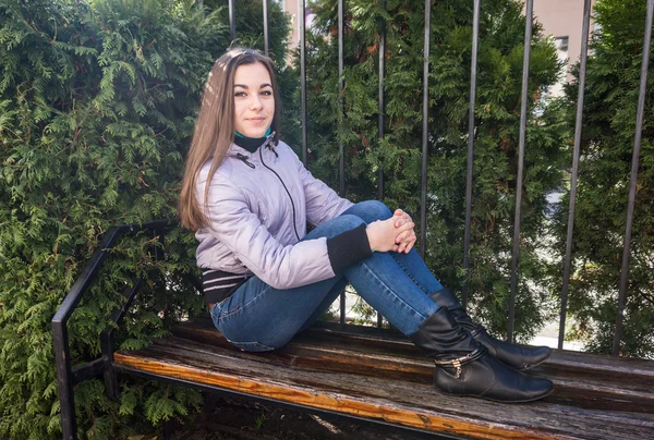 Ritratto di una ragazza seduta sul beanch nel parco — Foto Stock