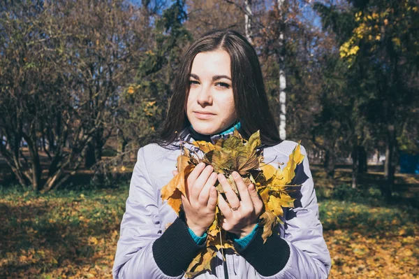 Adolescent et le bras de feuilles jaunes d'automne — Photo