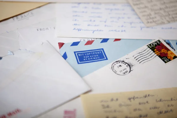 Diferentes cartas y papeles que rodean un sobre de correo aéreo azul —  Fotos de Stock
