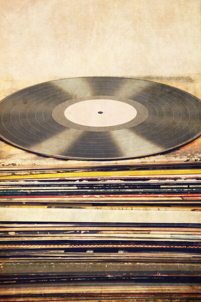 Vinyl record on a tower of album covers, textured, vintage, retro