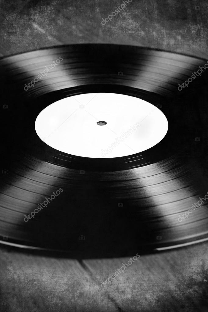 Vinyl record with white label on a wooden floor, black and white, retro