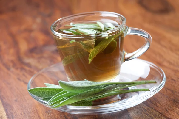 Té de hierbas hecho de salvia fresca en el suelo de madera, hoja de salvia en frente, salvia fresca dentro de la taza de té , — Foto de Stock