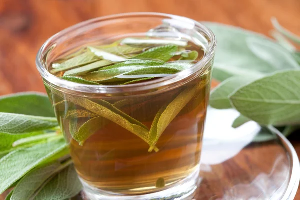 Sage tea in glass on wooden floor — Stock Photo, Image