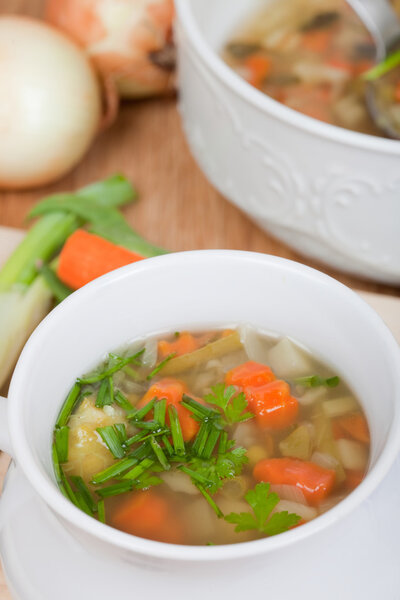 Colorful vegetable soup, ingredients carrot, beans, onion, garlic, on wooden plate
