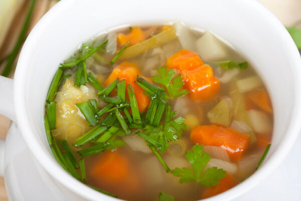 Fresh vegetable soup with carrots, onion, garlic, herbs