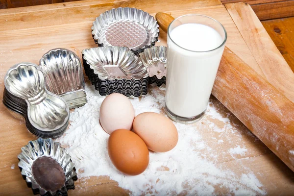 Ingredienti per biscotti natalizi, uova, latte, farina, tagliabiscotti, mattarello — Foto Stock