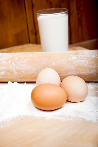 Ingredientes de masa en mesa de madera, huevos, leche, harina, rodillo Fotos de stock libres de derechos